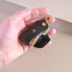 Leather Key Holder in Black with brass clip by Nitmoi, being held in hand